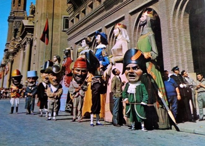 Tarjeta de la decada de los años 60 del siglo pasado, con los Gigantes y Cabezudos en exposición delante del ayuntamiento, para que los disfruten niños y mayores, preparados para las fiestas de la ciudad